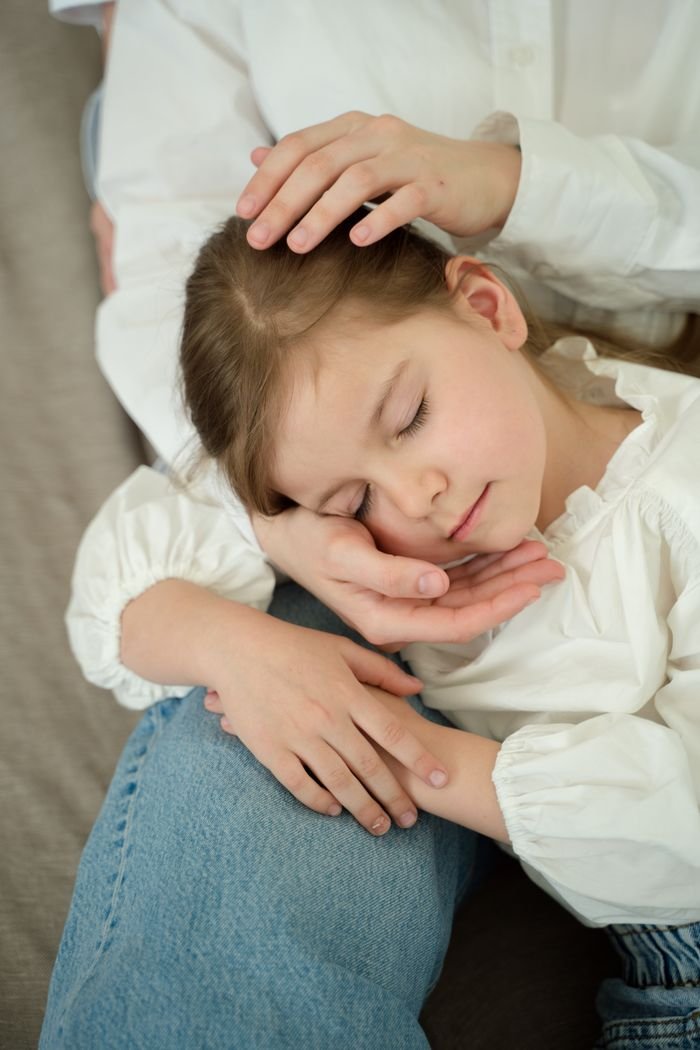 A heartwarming scene of a mother gently holding her sleeping daughter, showcasing love and tenderness.